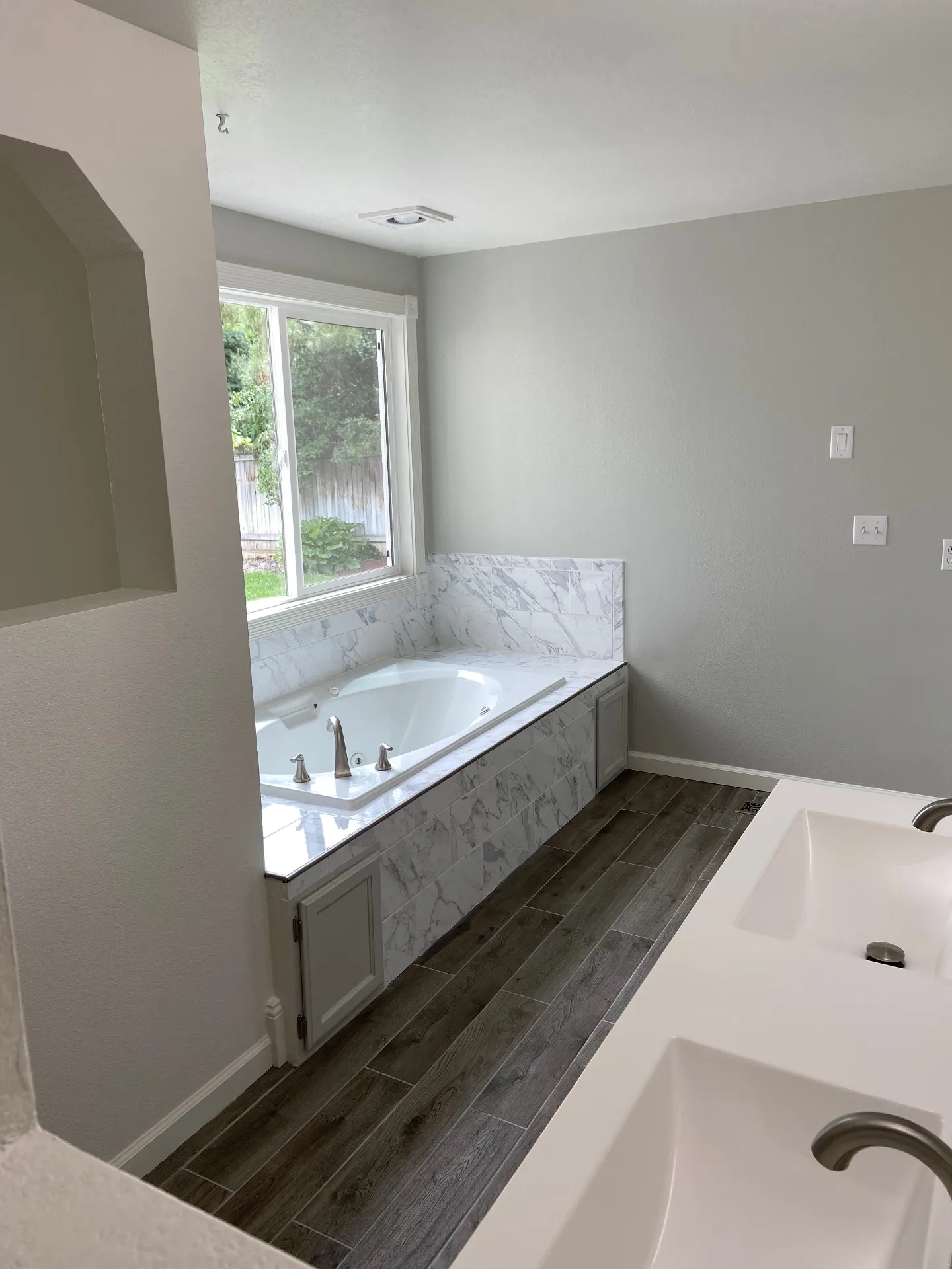 New bathtub with marble tile surround