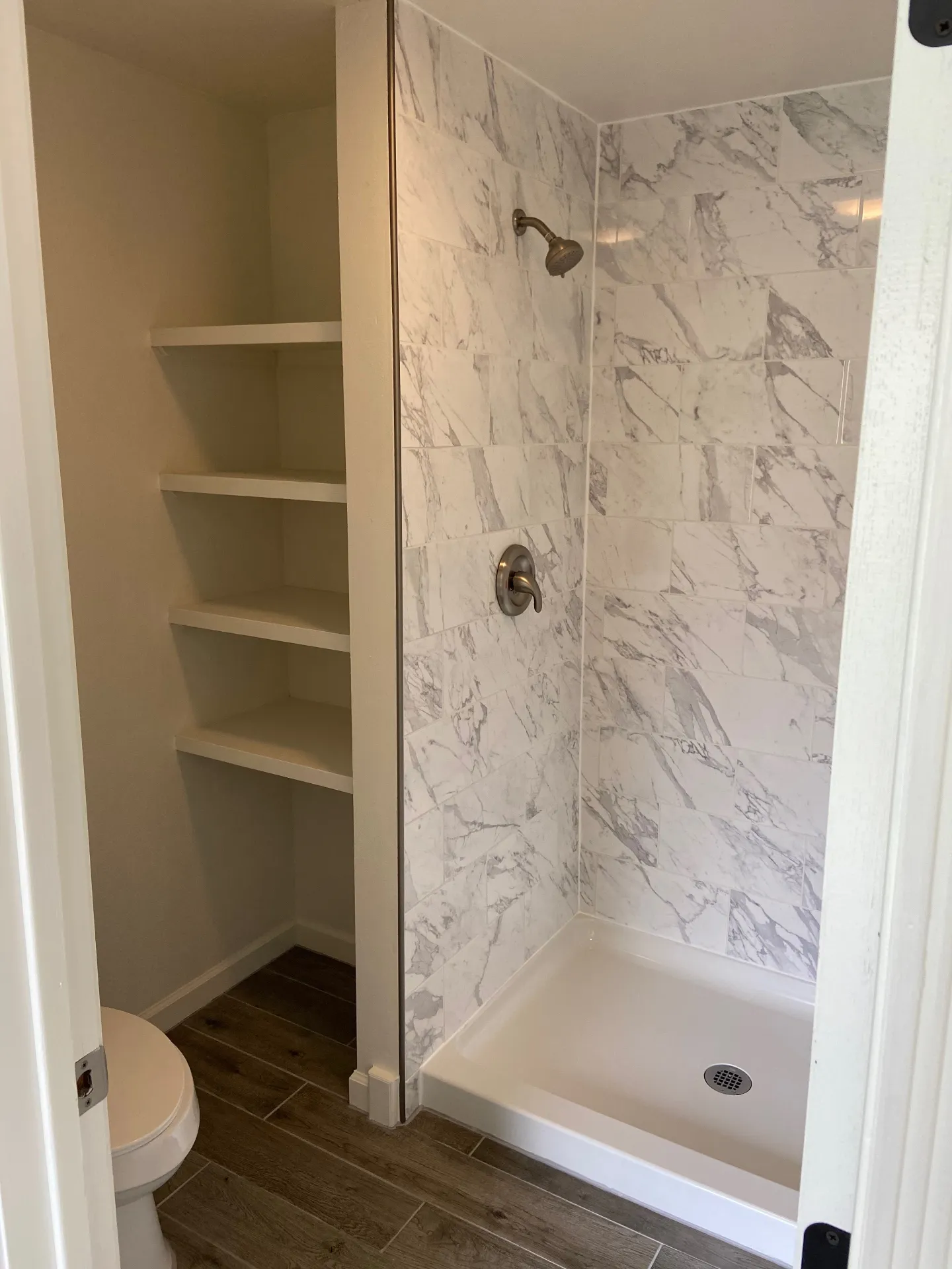 New walk-in shower with marble tile and new toilet
